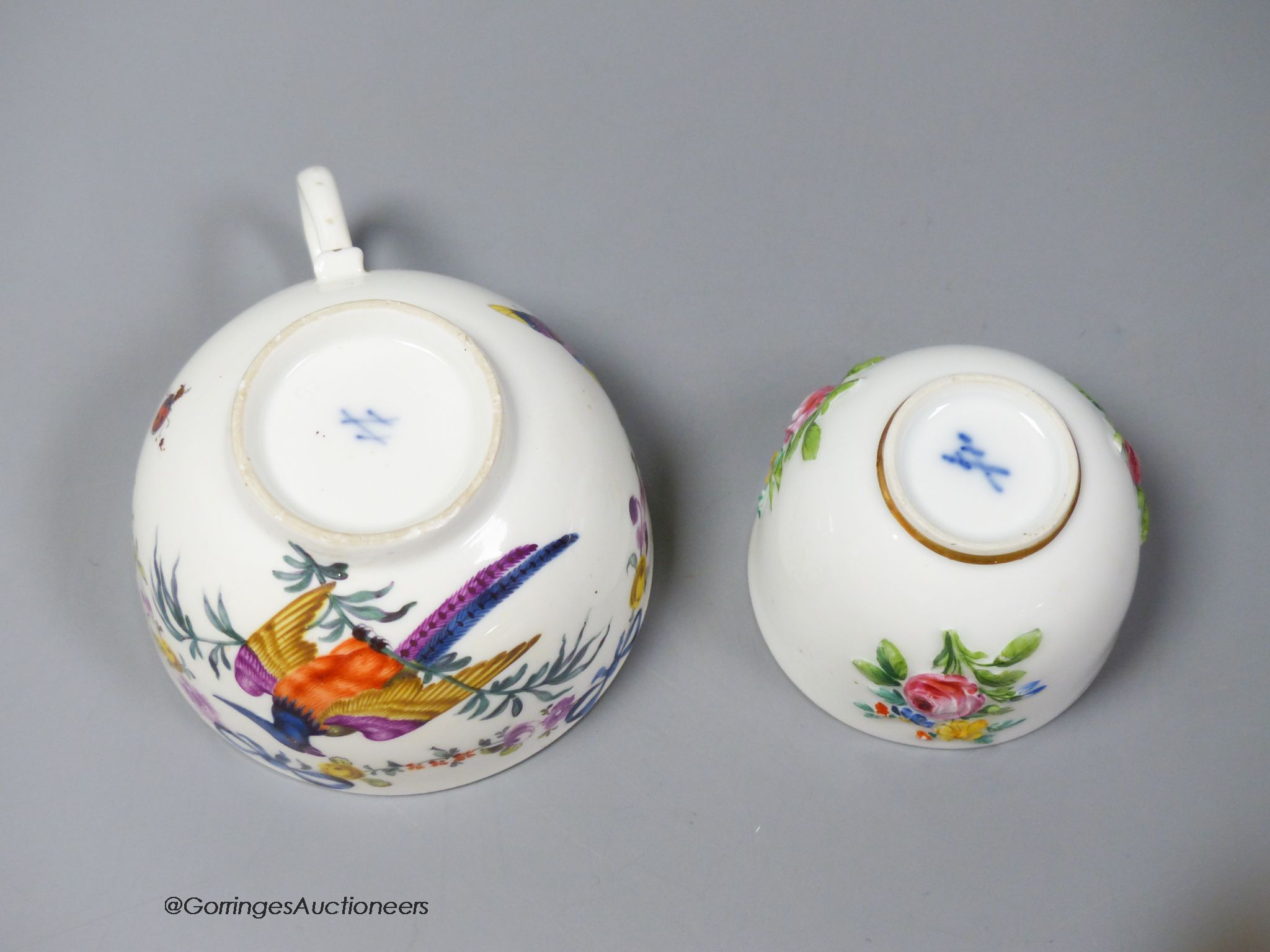 A Meissen bowl, c.1750, moulded and painted with flowers, 6cm diameter and Meissen cup, c.1750 painted with a parrot and flowers (2)